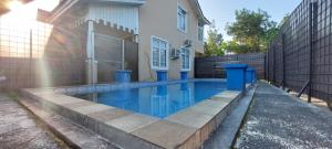 a swimming pool in front of a house at Vila Dalia Puncak Nb4-01 in Cikundul