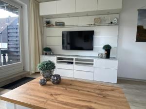 a living room with a tv and a table at Ferienwohnung Fichtenweg in Winterberg