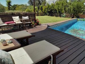 a wooden deck with chairs and a swimming pool at Manta Rota Beach, Bed & Breakfast in a villa,privat pool in Manta Rota