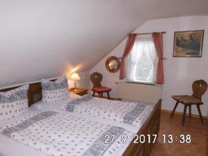 a bedroom with a bed and two chairs and a window at Familienferienwohnung im Haus Ludwig in Masserberg