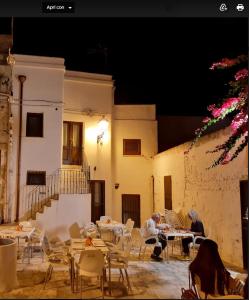 a group of people sitting at tables in a courtyard at B&B Suite "Caniglia" in Mesagne