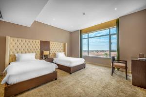 um quarto de hotel com duas camas e uma janela em Suknai Royal Hotel em Hail