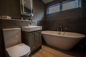a bathroom with a toilet and a tub and a sink at High Oaks Grange - Contemporary Lodges in Pickering +40 photos