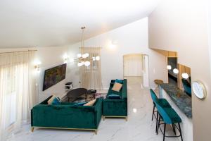 - un salon avec deux canapés verts et une table dans l'établissement Villa M&M, à Budva