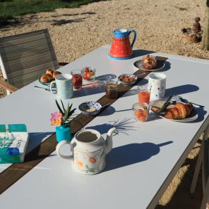uma mesa com pequeno-almoço de café e croissants em Le cottage du séquoia em Chamberet