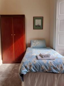a bedroom with a bed next to a closet at Commodore Guesthouse, Self-Catering Suites in Rothesay