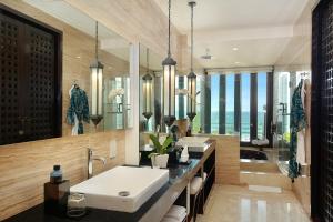 a bathroom with two sinks and a large window at The Seminyak Beach Resort & Spa in Seminyak