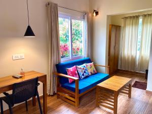 a living room with a blue couch and a table at Flower Valley Plantation Homestay in Munnar