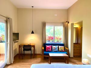 a living room with a blue couch and a window at Flower Valley Plantation Homestay in Munnar