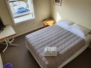 Un pat sau paturi într-o cameră la Fernlodge Inglewood