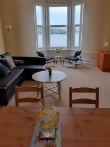 ein Wohnzimmer mit einem Sofa und einem Tisch in der Unterkunft Commodore Guesthouse, Self-Catering Suites in Rothesay