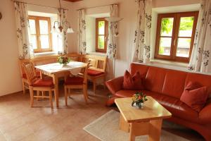 uma sala de estar com um sofá e uma mesa em Ferienwohnung Fritzenwenger em Übersee