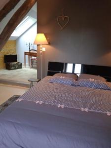 Un dormitorio con una cama morada con un corazón en la pared en La Lisière du Morvan, en Magny-Lormes