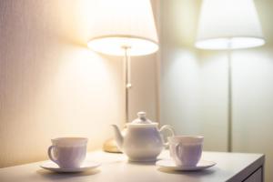a table with two tea cups and a lamp at Hotel A in Saratov