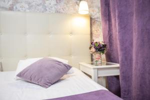 a bed with a purple pillow next to a table at Hotel A in Saratov