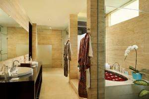 a bathroom with a sink and a tub and a shower at The Seminyak Beach Resort & Spa in Seminyak