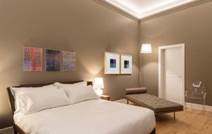 sypialnia z białym łóżkiem i krzesłem w obiekcie BSJ15-Borgo San Jacopo Room we Florencji +37 zdjęć