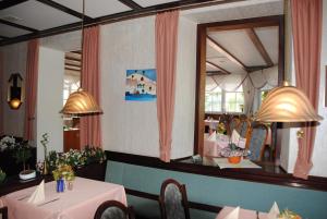 a dining room with two tables and a mirror at Hotel Kurfürst Garni in Germersheim