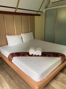 a bed with two towels on top of it at Kurina Hotel in Bangkok