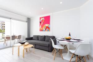 een woonkamer met een bank, een tafel en stoelen bij Ocean Garden FL FREE WIFI in Playa Paraiso