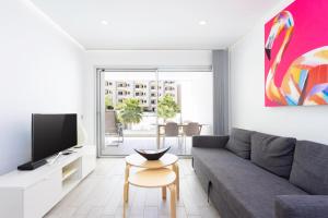 een woonkamer met een bank en een tv bij Ocean Garden FL FREE WIFI in Playa Paraiso