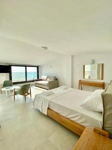 a large bedroom with a large bed and a couch at Vit'S sea Villa in Siviri