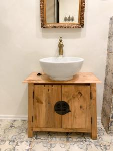 ein Waschbecken auf einem Holzständer mit einem Spiegel in der Unterkunft Charzykówka Domek na Kaszubach in Charzykowy