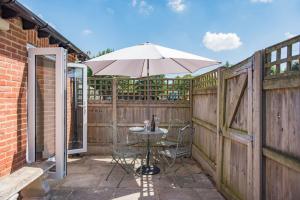 una mesa con sombrilla en el patio en The Roost by Bloom Stays en Wingham