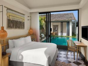 a bedroom with a bed and a swimming pool at New World Phu Quoc Resort in Phu Quoc