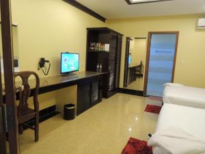 a room with a desk with a television and a bed at Kampongbay Makeng Guesthouse in Kampot