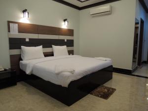 um quarto com uma cama grande e lençóis brancos em Kampongbay Makeng Guesthouse em Kampot