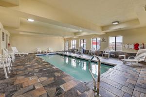 a pool in a hotel with chairs at Comfort Inn East in Indianapolis