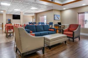 a waiting room with a blue couch and chairs at Comfort Inn & Suites Statesboro - University Area in Statesboro