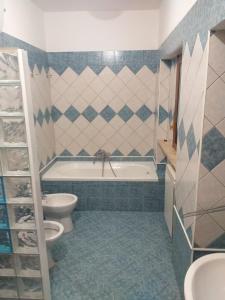 ein Badezimmer mit einer Badewanne, einem WC und einem Waschbecken in der Unterkunft villino 4 posti letto con cucina a 30mt dal mare in Fiumicino