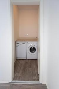 a laundry room with a washing machine and a washer at Zentral gelegene, helle Studio Apartments in Nürnberg