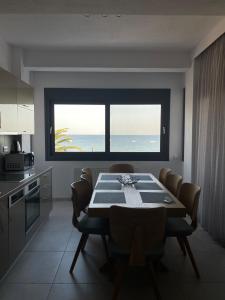 a dining room with a table and a view of the ocean at Vit'S sea Villa in Siviri