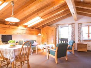 een woonkamer met houten plafonds en een tafel en stoelen bij Ahorn-Appartements - Chiemgau Karte in Inzell