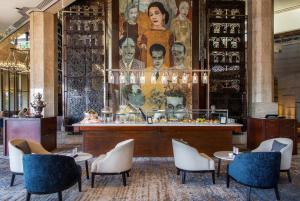 una hall con tavoli e sedie e un grande dipinto di InterContinental Cairo Semiramis, an IHG Hotel a Il Cairo
