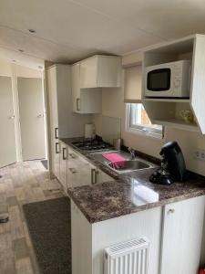 a kitchen with a sink and a microwave at RBR 722 - Beach Resort Kamperland in Kamperland