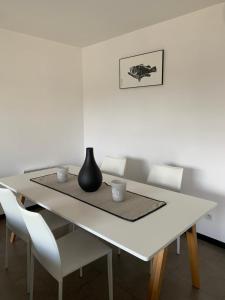 a white table with two cups and a vase on it at Appartement F2 Salines de Porto Vecchio in Porto-Vecchio