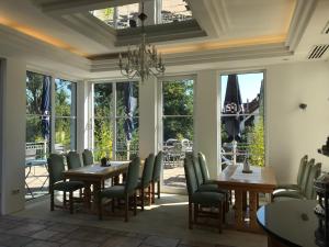 una sala da pranzo con tavoli, sedie e finestre di Waldhotel Felsentor a Hauenstein