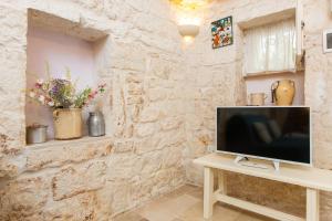 a living room with a television on a table at Lovely Stone House In Ostuni in Ostuni