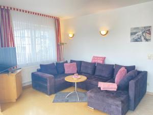 a living room with a blue couch and a table at Ferienwohnung Schmachter See in Binz