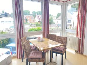 a dining room with a table and chairs and windows at Ferienwohnung Schmachter See in Binz