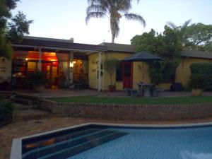 dom z basenem przed nim w obiekcie Jubilee Lodge Guest House w mieście Johannesburg