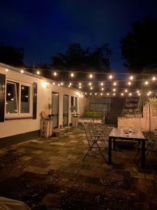 une terrasse avec une table et des lumières sur une remorque dans l'établissement Loods 123 bed & kitchen, à Landgraaf