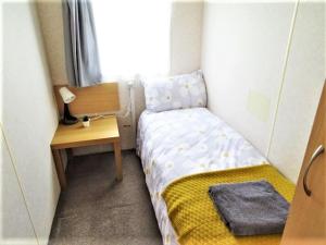 a small bedroom with a bed and a desk at Devon Barnstaple Self Catering Accommodation Tarka Holiday Park, A14 Free Wi-Fi Spacious Tarka Holiday Park sleeps 5 Pets allowed Static Caravan home Devon EX31 4AU just 6 miles from Saunton Sands in Barnstaple