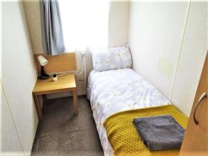 a small bedroom with a bed and a desk at Devon Barnstaple Self Catering Tarka Holiday Park Free Wi-Fi Spacious Static Caravan sleeps 4 Pets allowed location Devon EX31 4AU Just 6 miles from Saunton Sands Please note no sign written vehicles are allowed to park on the holiday park overnight in Barnstaple