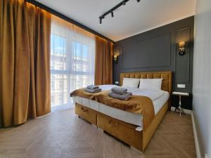 a bedroom with a large bed and a large window at Silesia Aparthotel in Szczecin