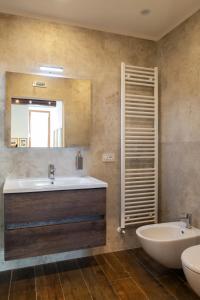 uma casa de banho com um lavatório, um WC e um espelho. em Camere Capobove Assisi em Assis